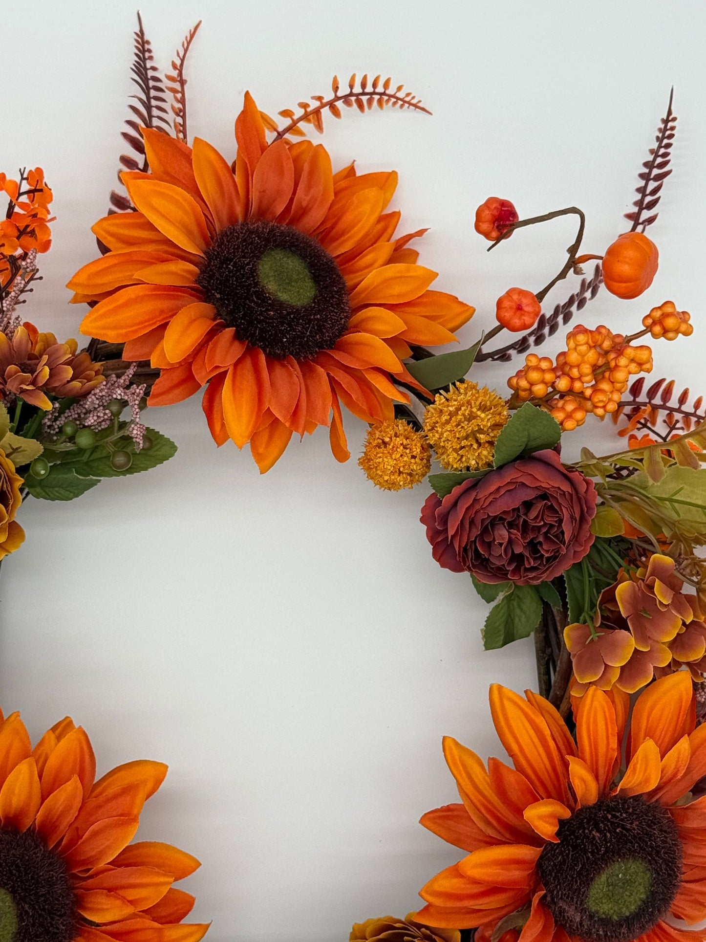 Decorative wreath with sunflowers and autumnal flowers on a white background
