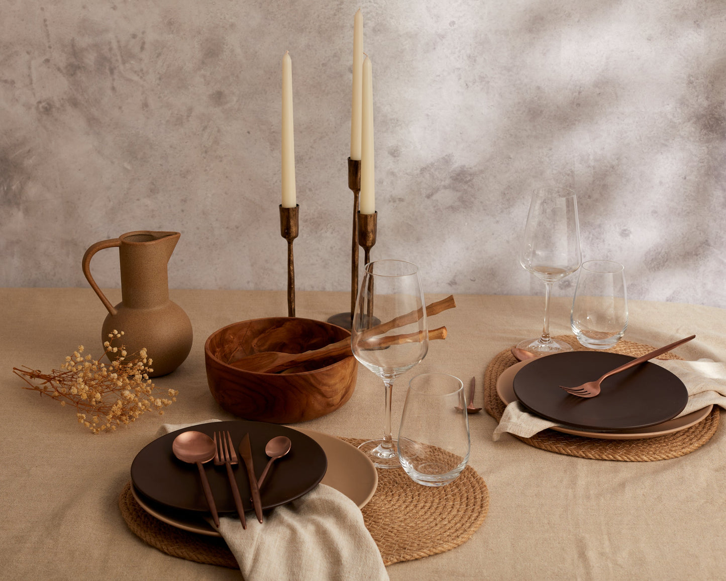 London rose gold cutlery set styled in a luxury dining setting with brown plates and glasses