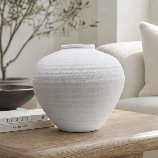 White textured ceramic vase on a wooden table in a lounge