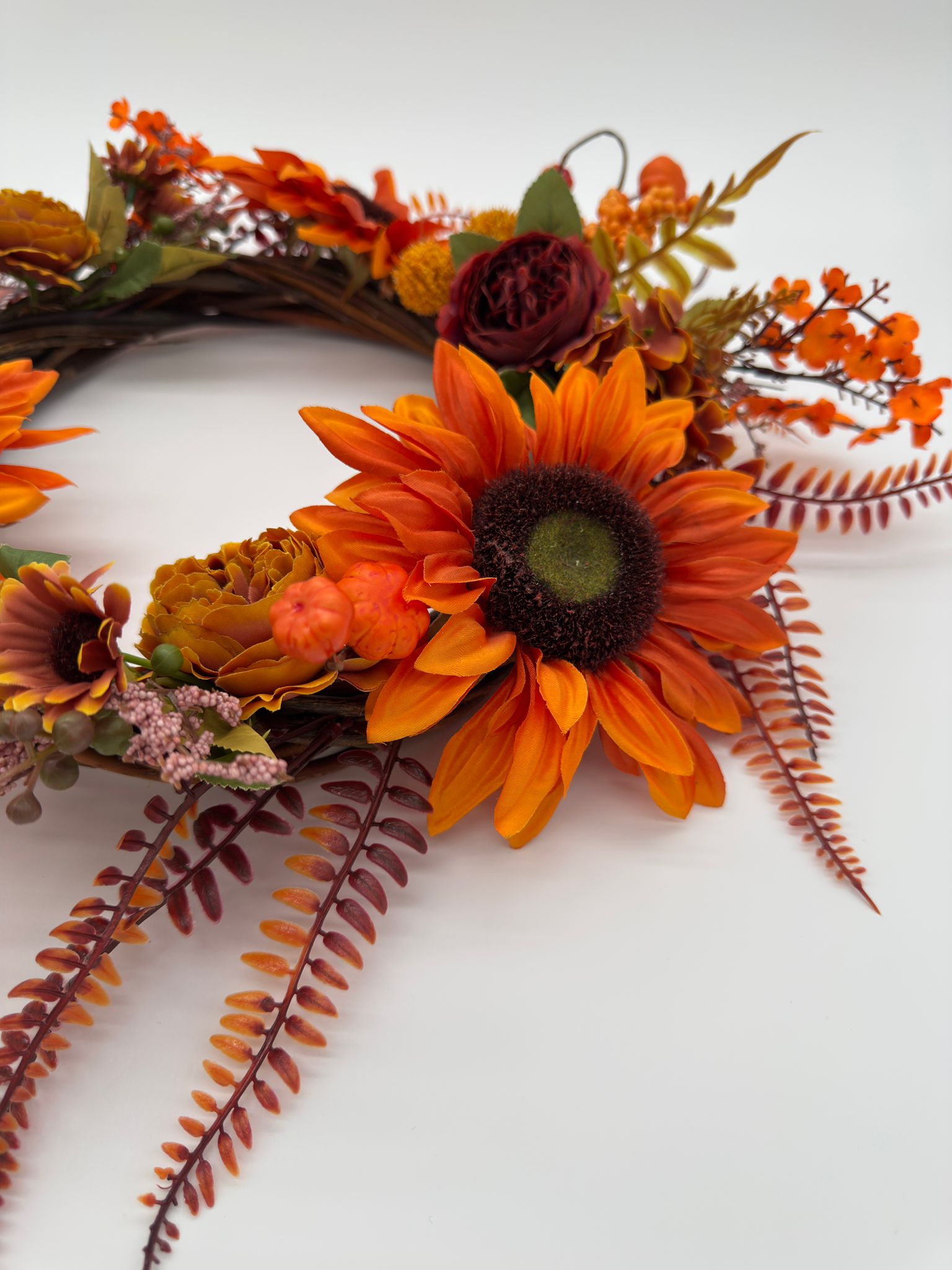 Decorative wreath with sunflowers and autumn leaves on a white background