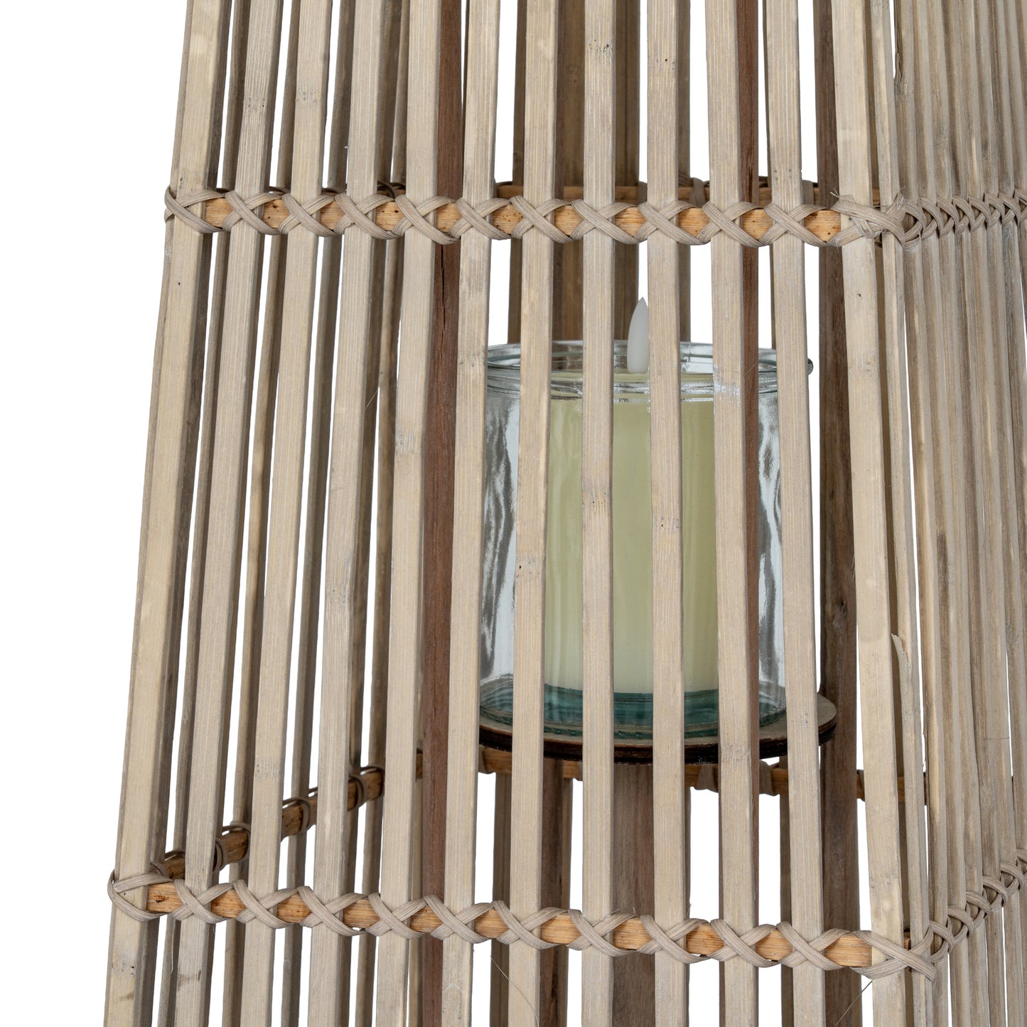 Candle in a glass holder inside a rattan lantern on a white background