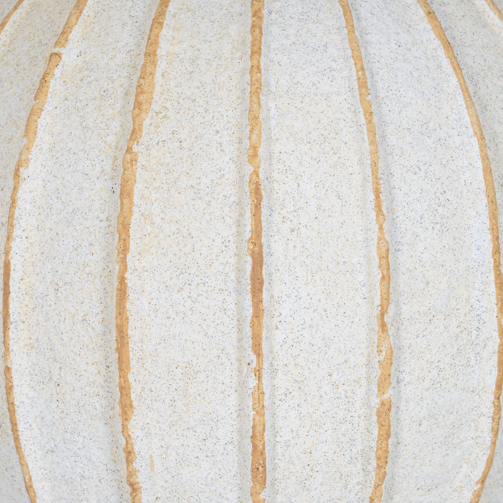Close-up of a textured surface with vertical beige stripes on a white background