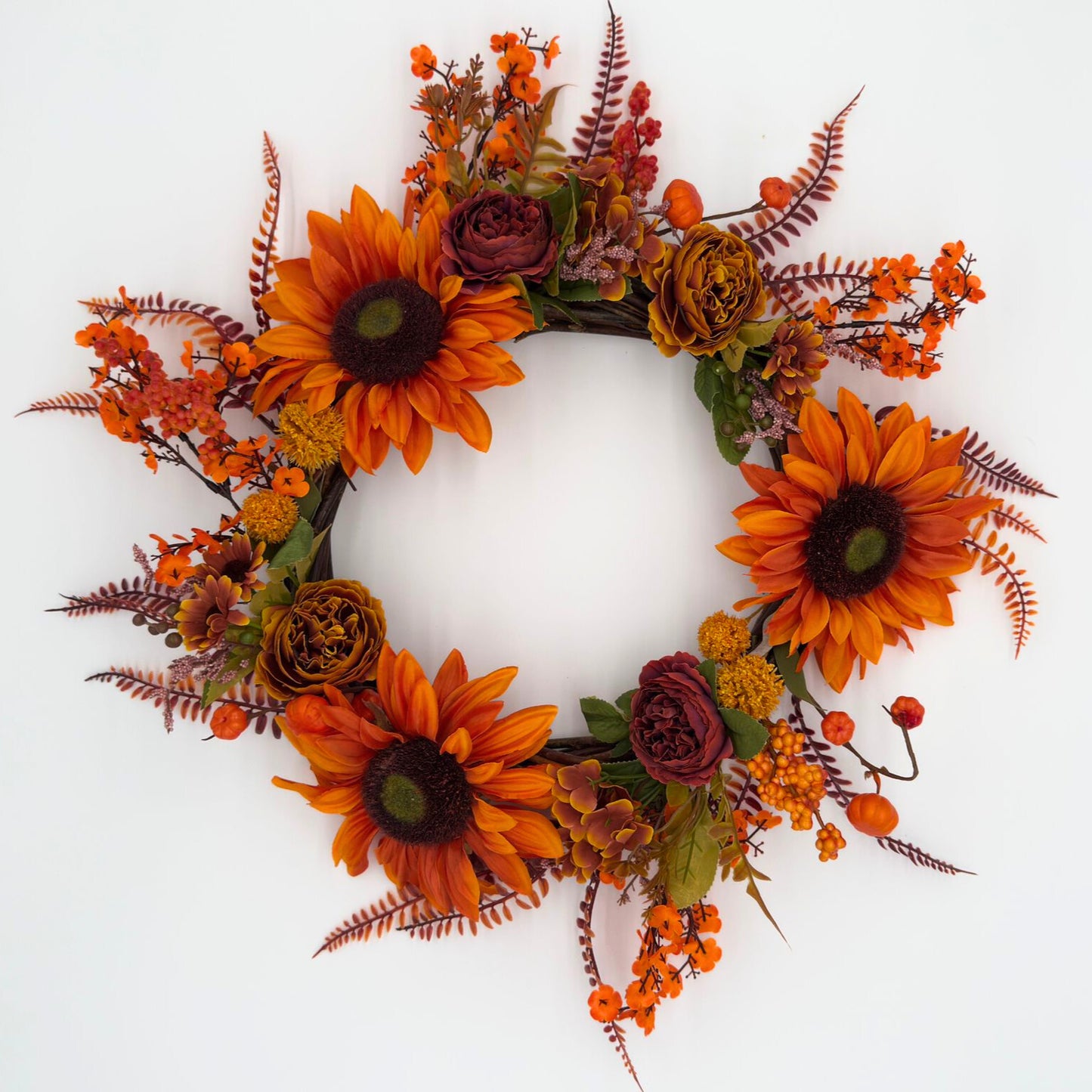 Autumn-themed floral wreath with sunflowers and other fall flowers on a white background
