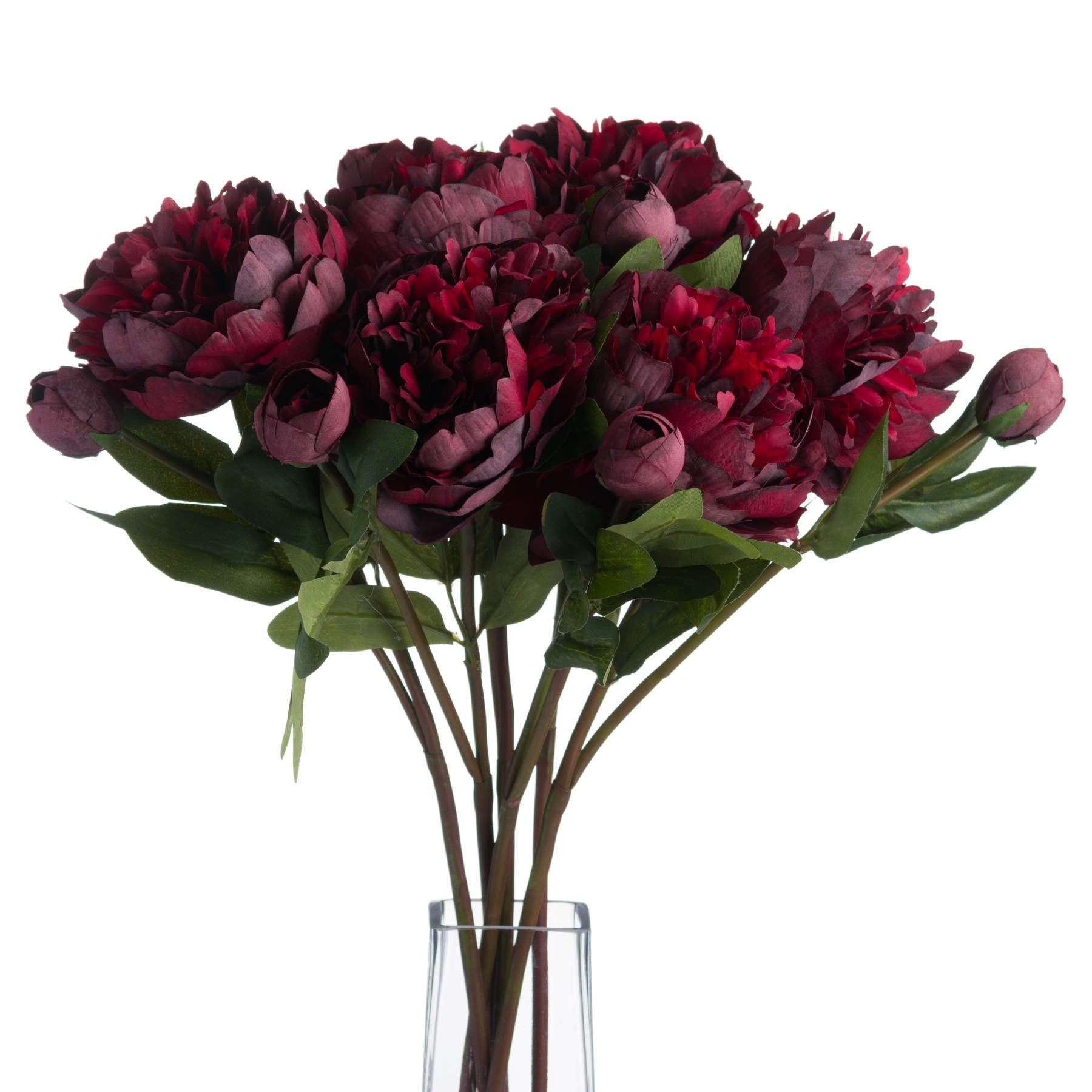 Bouquet of dark red artificial flowers in a clear vase on a white background