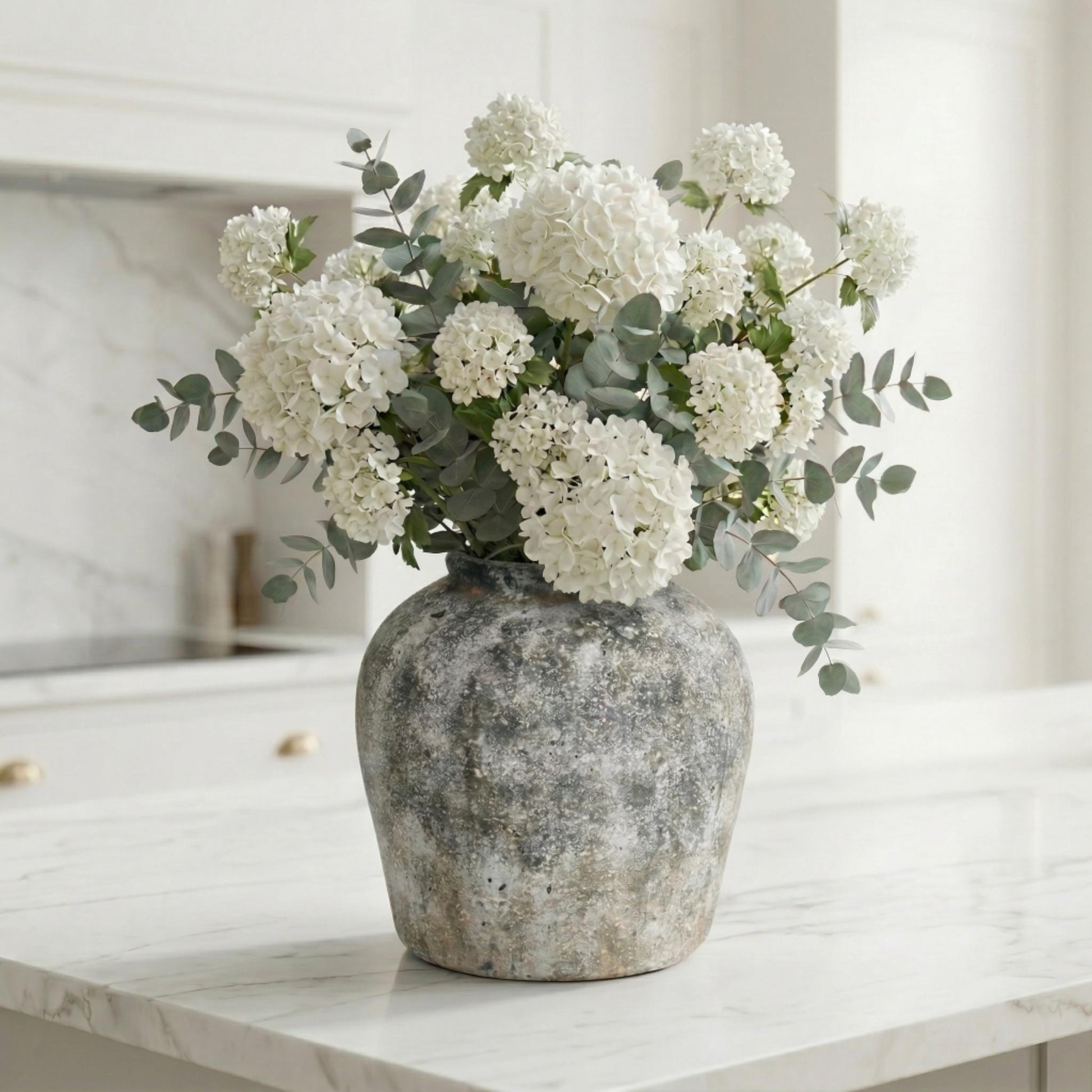 Aged Stone Ceramic Vase styled with white hydrangeas and eucalyptus on a marble surface — rustic stoneware effect decorative vase from Artanna
