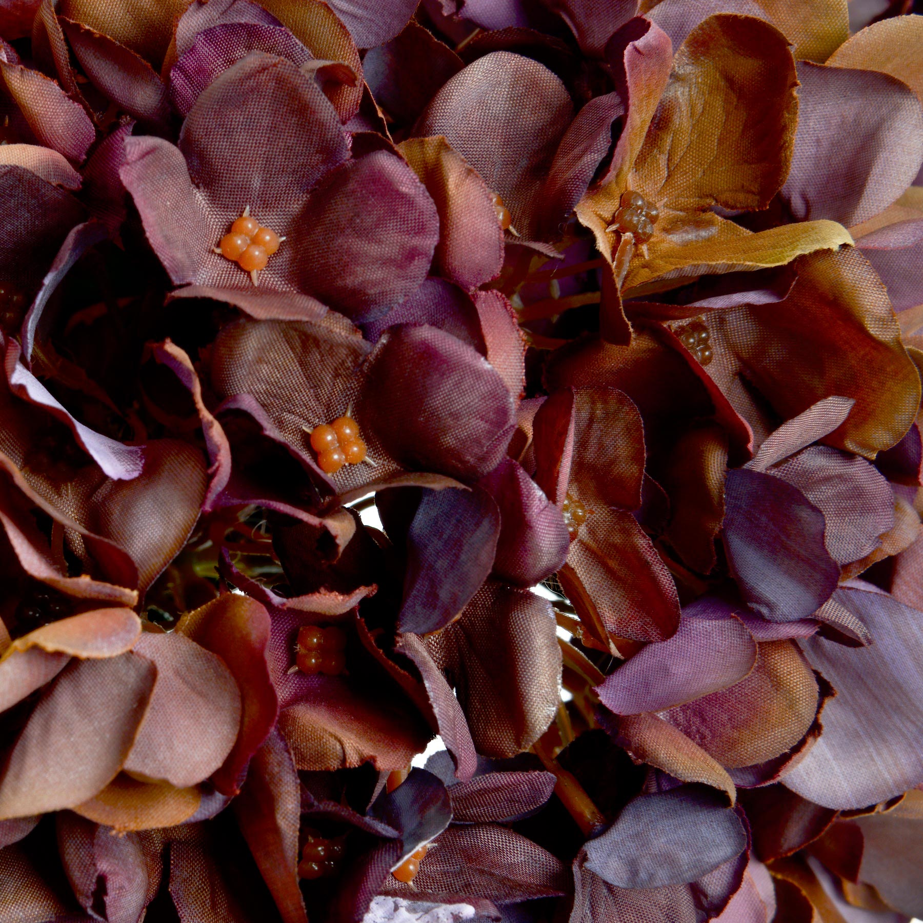 Close-up of a artificial hydrangea petals with purple and orange flowers.