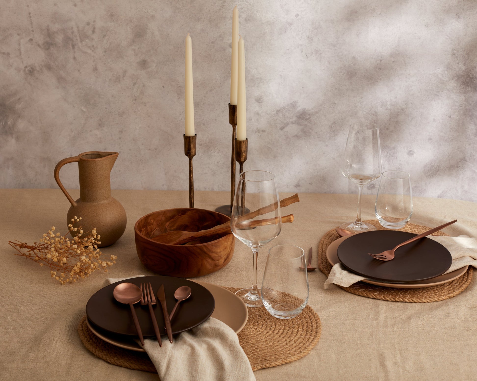 London rose gold cutlery set styled in a luxury dining setting with brown plates and glasses